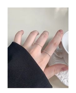 Close-up of minimalist S925 sterling silver thin rings with sparkling texture on fingers