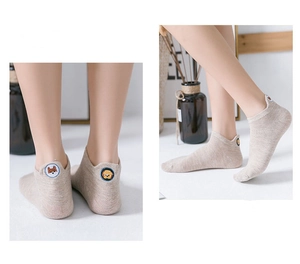 Detailed view of beige cotton low cut socks with small animal embroidery on the heel