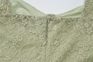 Dettaglio del retro dell'abito in pizzo verde chiaro con cerniera invisibile e ricami