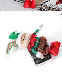 Detailed view of plush Christmas elf figurine being weighed on a digital scale for accuracy