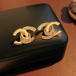 Macro shot of 18k gold plated double C earrings with micro-paved zircons on black leather
