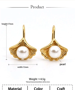 Detail view of 316L stainless steel ginkgo leaf earrings with a white pearl accent