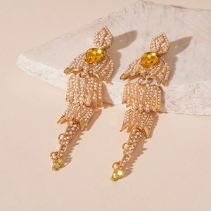 Detail of vintage gold drop earrings with white pearls and yellow crystal stones