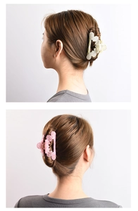 Detail showing elegant gold and pink glitter hair claws styled on model's hair