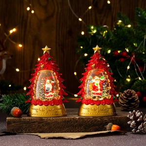 Christmas tree snow globe lanterns with Santa Claus figurines and golden bases