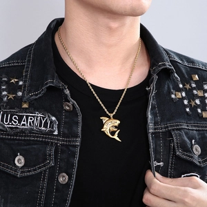 Detail of a hip-hop style golden shark pendant necklace worn on a denim jacket