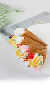 Detailaufnahme realistischer Eistüten-Anhänger mit Waffelstruktur und Sahnehäubchen
