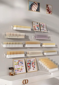 Close-up of wall-mounted clear acrylic tiered shelves for nail polish display and storage