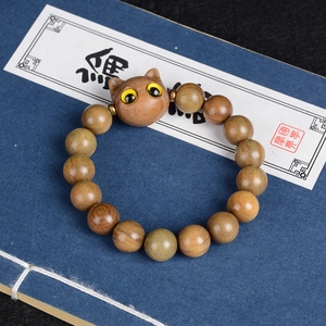 Bracelet chat en bois de santal avec perles naturelles sur un livre bleu vintage