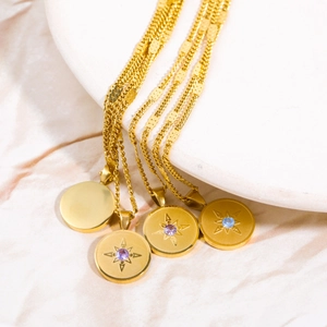 Detail of 18K gold plated stainless steel birthstone necklaces with starburst engraving