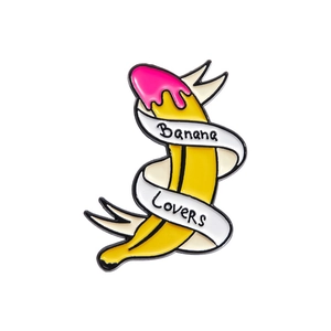 Detailed macro view of an enamel banana brooch with pink drip and white ribbon details