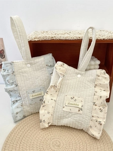 Minimalist floral quilted wrist bag with cotton padding and lace trim in a cozy home setting