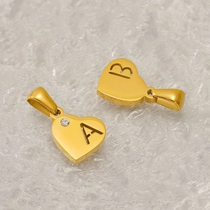 Goldener Herzanhänger aus Edelstahl mit Zirkonia und gravierten Buchstaben A und B im Detail