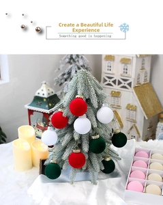 Gros plan de boules de Noël floquées rouges, blanches et vert foncé sur un sapin