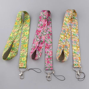 Close-up of three polyester floral lanyards with metal clasps in green and pink