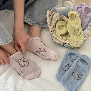 Detail of sweet cotton socks featuring cute cartoon dog patterns and ruffled edges