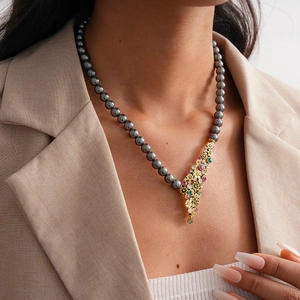 Detail of vintage flower pendant with colorful crystals on dark grey pearl necklace