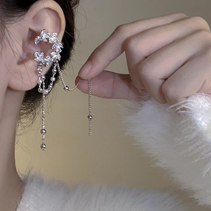 Detailed view of a silver crescent moon ear cuff featuring zircon stones and metal tassels