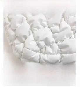 Macro view of white quilted padded texture with square stitching on the cloud bag
