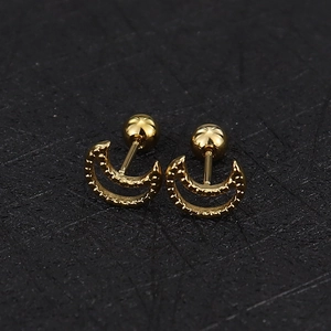 Macro shot of 16G gold crescent moon cartilage studs with screw ball backs