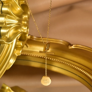 Detailed macro of gold-plated necklace with Good Luck engraving on round pendant