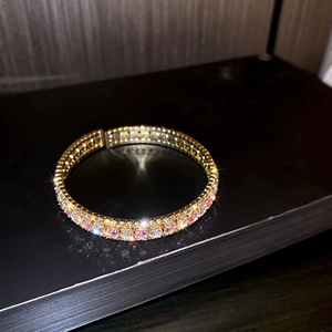 Detailed macro view of gold-plated double-row bracelet with pink and white cubic zirconia