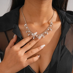 Détail du collier argenté avec perles et strass sur le cou du mannequin en haut noir