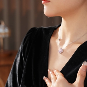 Detail view of pink zircon clover pendant necklace on a neck with elegant soft lighting