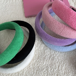 Detailed view of assorted colorful sponge headbands in soft terry cloth fabric texture