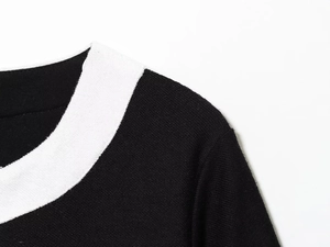 Gros plan détaillé du col contrasté noir et blanc sur une veste en maille fine