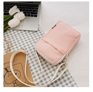 Detailed view of pink nylon crossbody phone bag with adjustable strap and front pocket