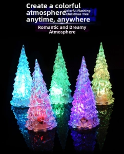 Five colorful LED crystal Christmas tree night lights reflecting on a black mirror surface
