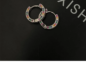 Macro shot of silver-tone hoop earrings with colorful rainbow cubic zirconia stones