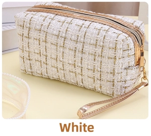 Details einer Tweed-Kosmetiktasche mit goldenem Reißverschluss und Webstruktur