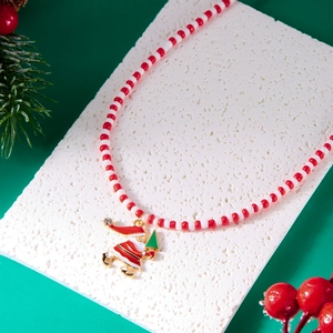 Handmade beaded Christmas necklace with a Santa pendant on a festive pine background