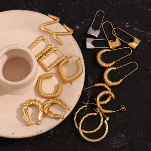 Artistic detail of assorted geometric 18K gold plated Z-shaped and spiral hoop earrings
