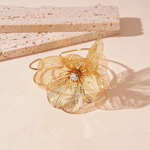 Détail macro du bracelet fleur dorée avec cristal et ombres artistiques élégantes