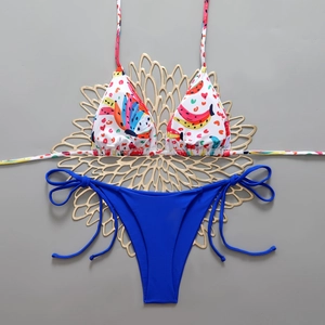 Detailed flat lay of a floral triangle bikini top and cobalt blue side-tie swim bottoms