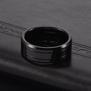 Macro shot of men's black tungsten ring with double grooves and polished mirror finish