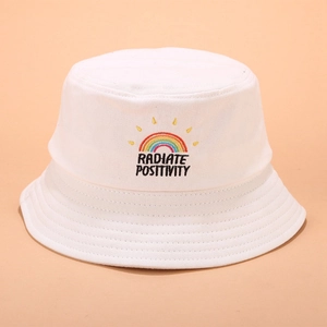Détail de la broderie arc-en-ciel et texte Radiate Positivity sur bob en coton blanc