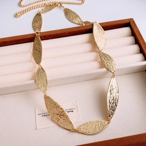 Detail of gold hammer-textured leaf-shaped pendant on jewelry display box