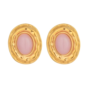 Detailed macro view of vintage gold stud earrings with oval pink natural stone inlay