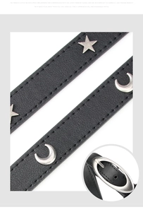 Close-up of black PU leather belt with silver star and moon rivets and oval buckle detail