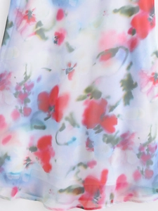 Close-up of semi-transparent chiffon fabric with vibrant red and pink floral prints