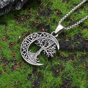 Silver tree of life crescent moon pendant with box chain on natural mossy background