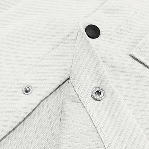 Close-up of light grey textured twill jacket featuring lapel collar and metal snaps
