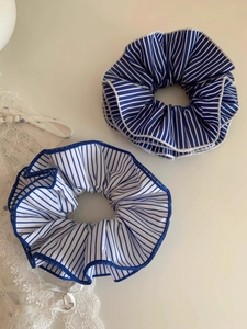 Detailed macro shot of blue and white striped fabric scrunchies with soft texture