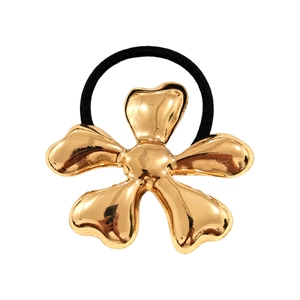 Detail of a metallic gold flower hair tie with an elastic black band on a white background
