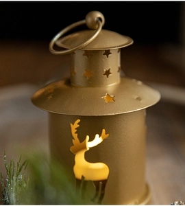 Close-up of a bronze metal Christmas lantern with elk and star cutout patterns