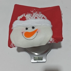 Detailaufnahme der Schneemann-Stuhlhusse auf einer Digitalwaage zeigt 165g Gewicht